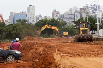 Motoniveladora e escavadeira trabalham na terraplanagem da área