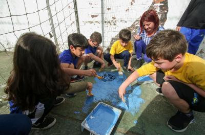 Educação ambiental do Dmae participa de ação de pintura em bueiros com crianças na zona Sul de Porto Alegre