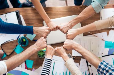 Equipe com as mãos posicionadas formando um círculo