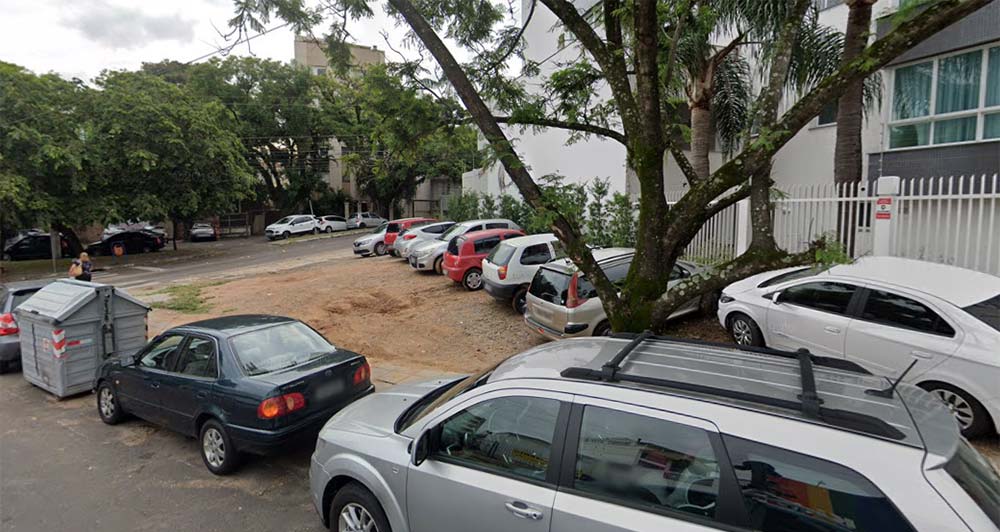 Terreno de esquina na Av. Neusa Brizola, com carros estacionados sobre a areia